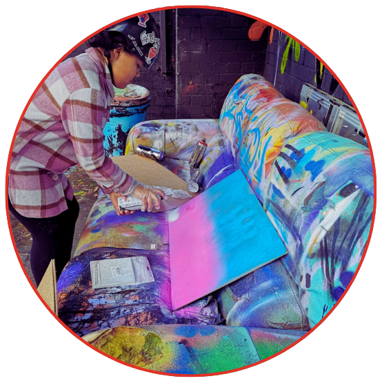 A woman paints a couch with various bright colors, demonstrating her artistic skills and adding vibrancy to the space.